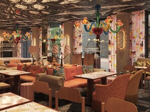 Ein Restaurantinnenraum mit Boxen, Tischen und einer Decke mit Fischmotiven.