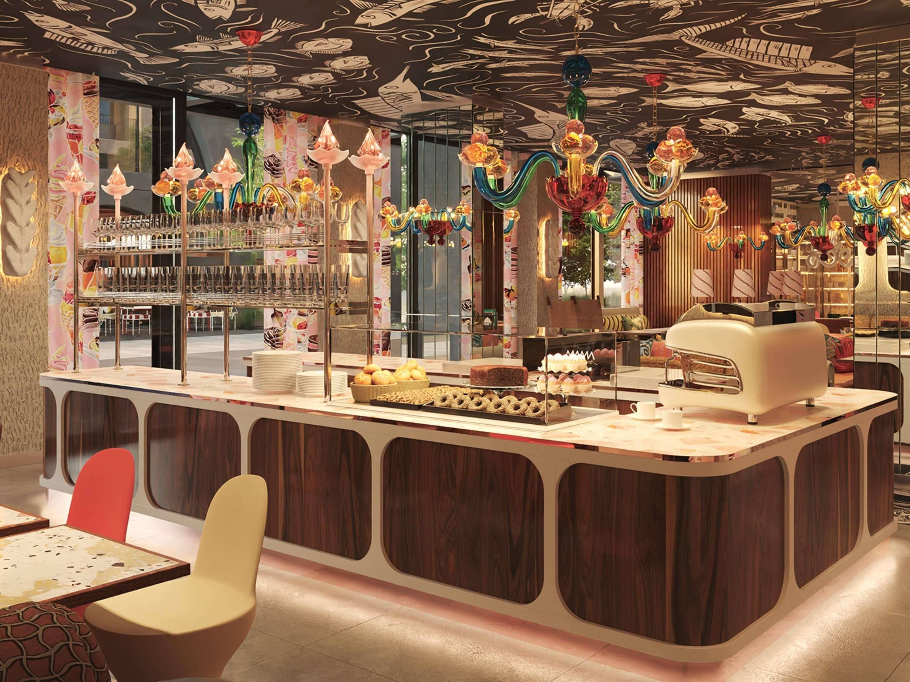 Un espace bar moderne doté d’un comptoir, de sièges et d’une collection de verres décoratifs.