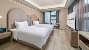 A hotel room with two beds, a TV, a desk, and a chair. - Mercure Guangzhou Financial City (Guangzhou)