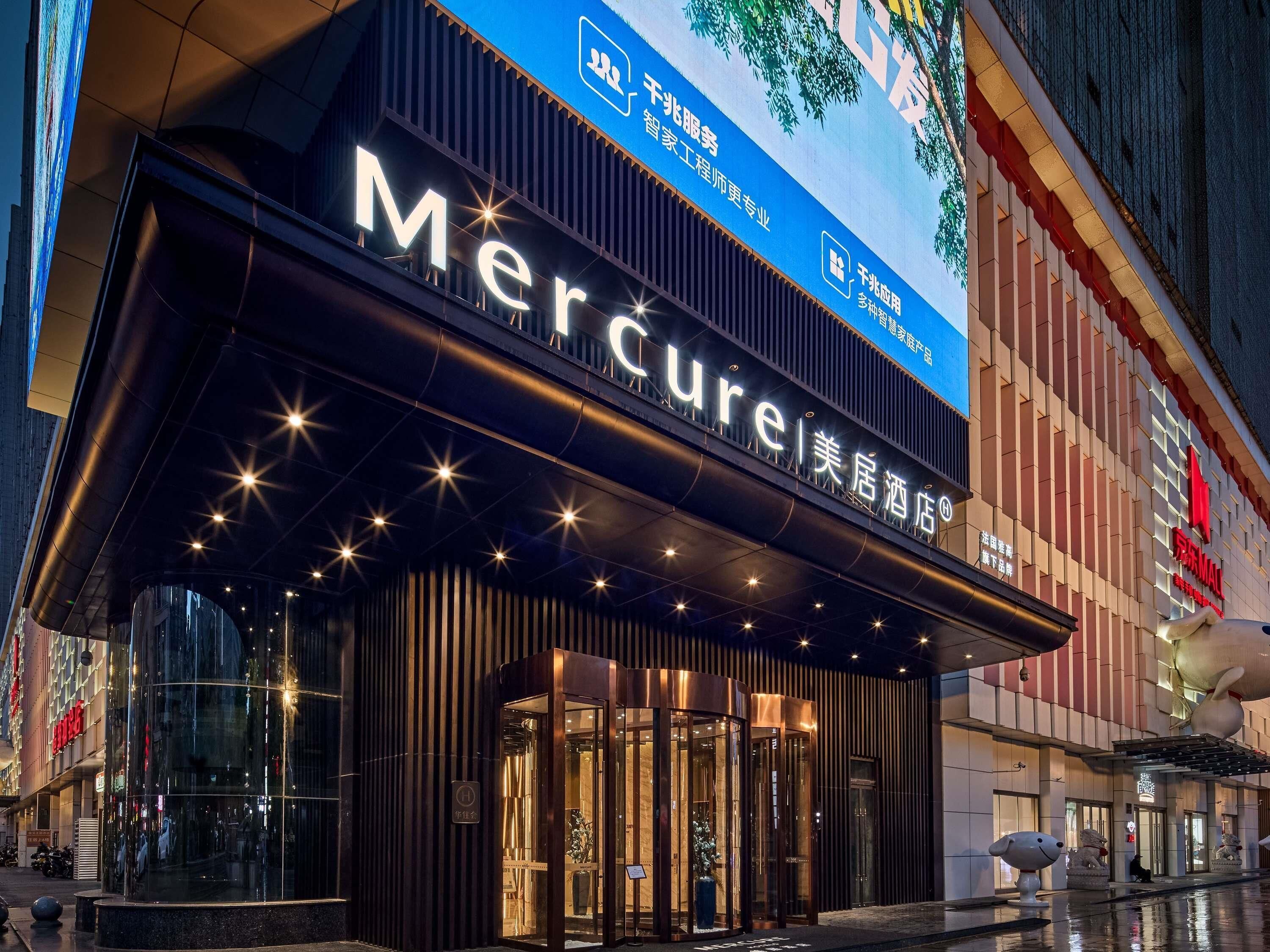 A hotel entrance with a prominent sign, glass doors, and a modern architectural design.