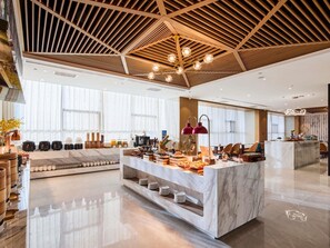 A modern hotel lobby with a marble reception desk, a coffee station, and a seating area. - Mercure Xi'An Daming Palace (Xi'an)