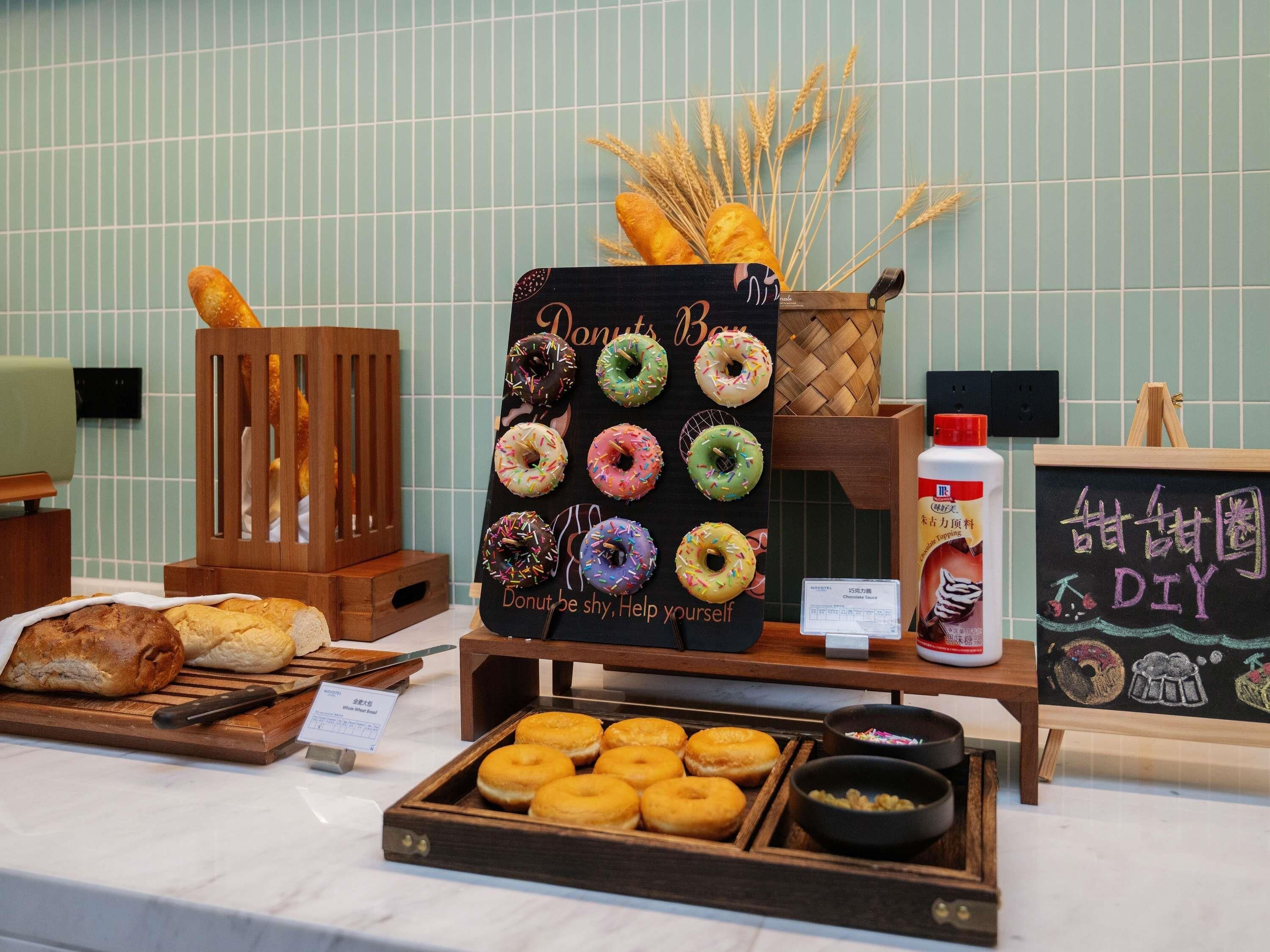 Una exhibición de rosquillas y pasteles con una pizarra.