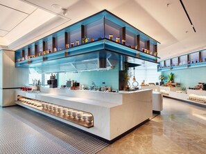Una cocina moderna con una isla central, estantes superiores e inferiores, y un suelo estampado.