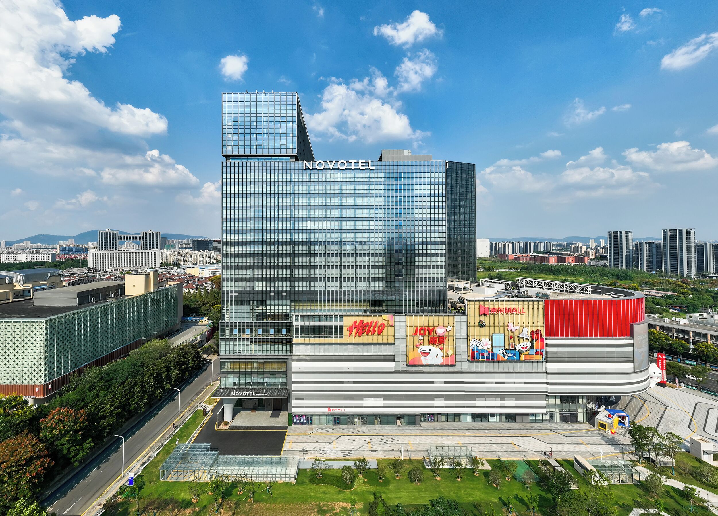 Un hôtel moderne doté d’une façade en verre remarquable, d’un espace sur le toit et d’un atrium central agrémenté d’une signalétique.
