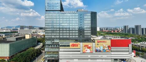 Un hôtel moderne doté d’une façade en verre remarquable, d’un espace sur le toit et d’un atrium central agrémenté d’une signalétique.