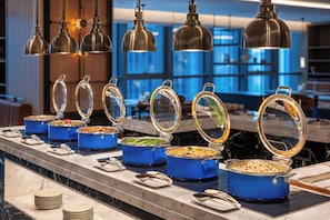 A buffet setup with various food containers and a marble countertop.