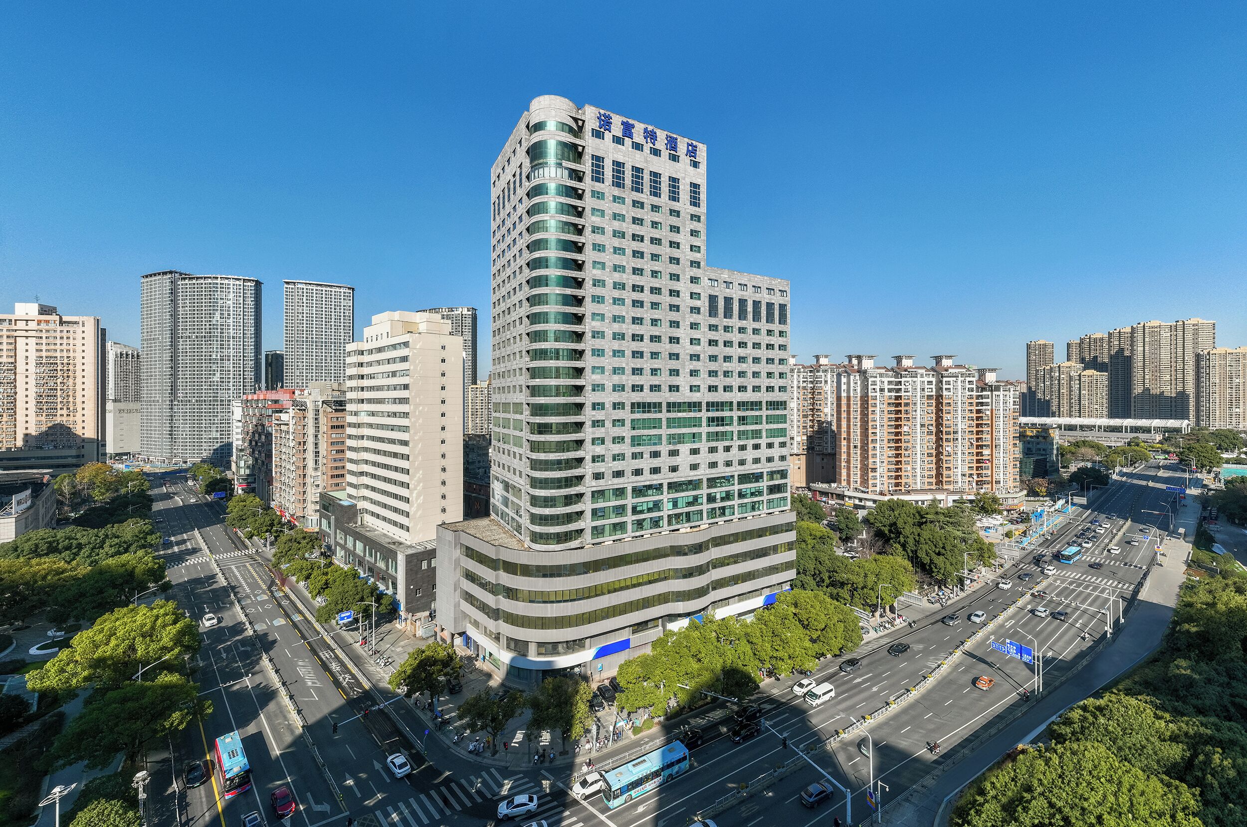 Un hôtel de grande hauteur au design moderne, avec de nombreux étages et situé dans un emplacement privilégié, à l’angle d’une rue.