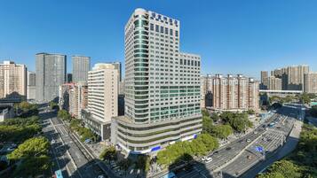 Un hôtel de grande hauteur au design moderne, avec de nombreux étages et situé dans un emplacement privilégié, à l’angle d’une rue.