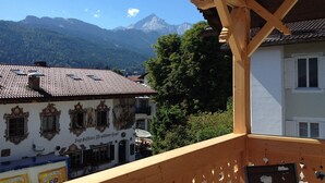 A building with a traditional European architectural style, featuring a balcony with a wooden structure. - Vacation apartment Haus Bader (Garmisch-Partenkirchen)