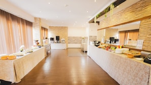 Een ruime hotel eetzaal met een buffetopstelling, inclusief een koffiehoek en diverse gerechten.