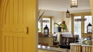 A dining area with a counter, chairs, and hanging lanterns. - Hotel De Brabantse Biesbosch (Werkendam)