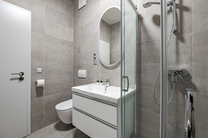 A modern bathroom with a toilet, sink, and shower. - A60 Boutique Hotel (Budapest)