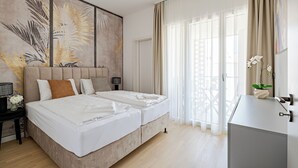 A bedroom with a bed, a nightstand, a lamp, a wall art piece, and a window with curtains. - A60 Boutique Hotel (Budapest)