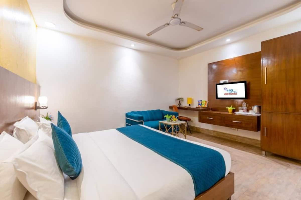 A hotel room with a bed, a desk, a television, and a wardrobe.