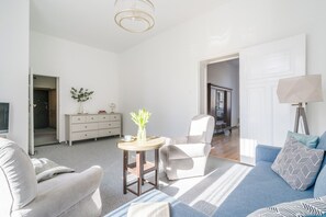 A modern living room with a sofa, armchair, and a small table with a vase. - Imperial Apartments - Nadmorska Przystań (Sopot)