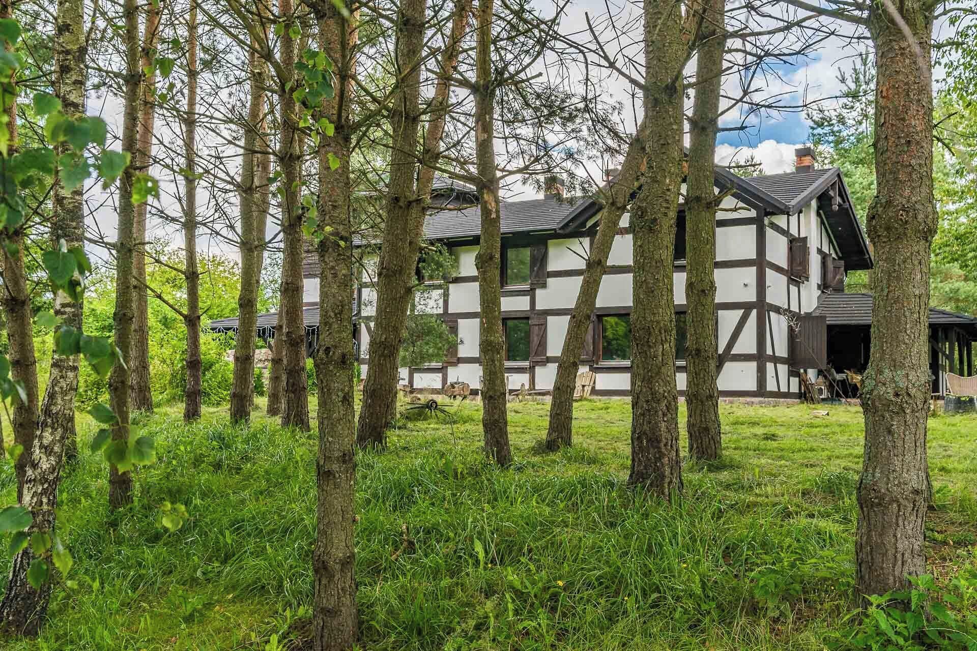 Una casa tradicional de entramado de madera rodeada de un bosque.