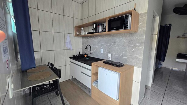 A compact kitchen with a microwave, coffee maker, and a small refrigerator.