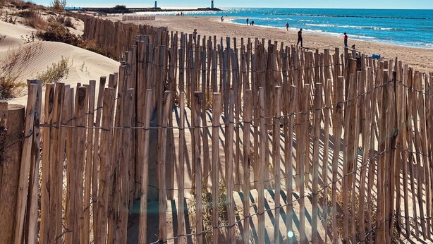 A beach with a wooden fence in the foreground, a sandy area, and the ocean in the background. - JF IMMO-VILLA RARE GARDEN PRIVATE POOL 10 PEOPLE SEA VIEW V0861 (Agde)