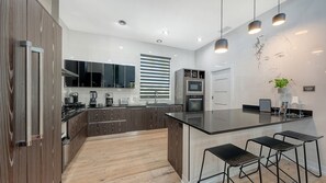 Fridge, microwave, oven, stovetop - Modern luxury retreat near Siesta Key with a heated saltwater pool, hot tub, private sports court, and cinema room. Fully furnished designer home with indoor-outdoor living, perfect for relaxing, entertaining, and enjoying the best of Sarasota. (Sarasota)