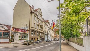 A street with buildings, a flag, and parked cars. - Imperial Apartments - GlobElite Sopot (Sopot)