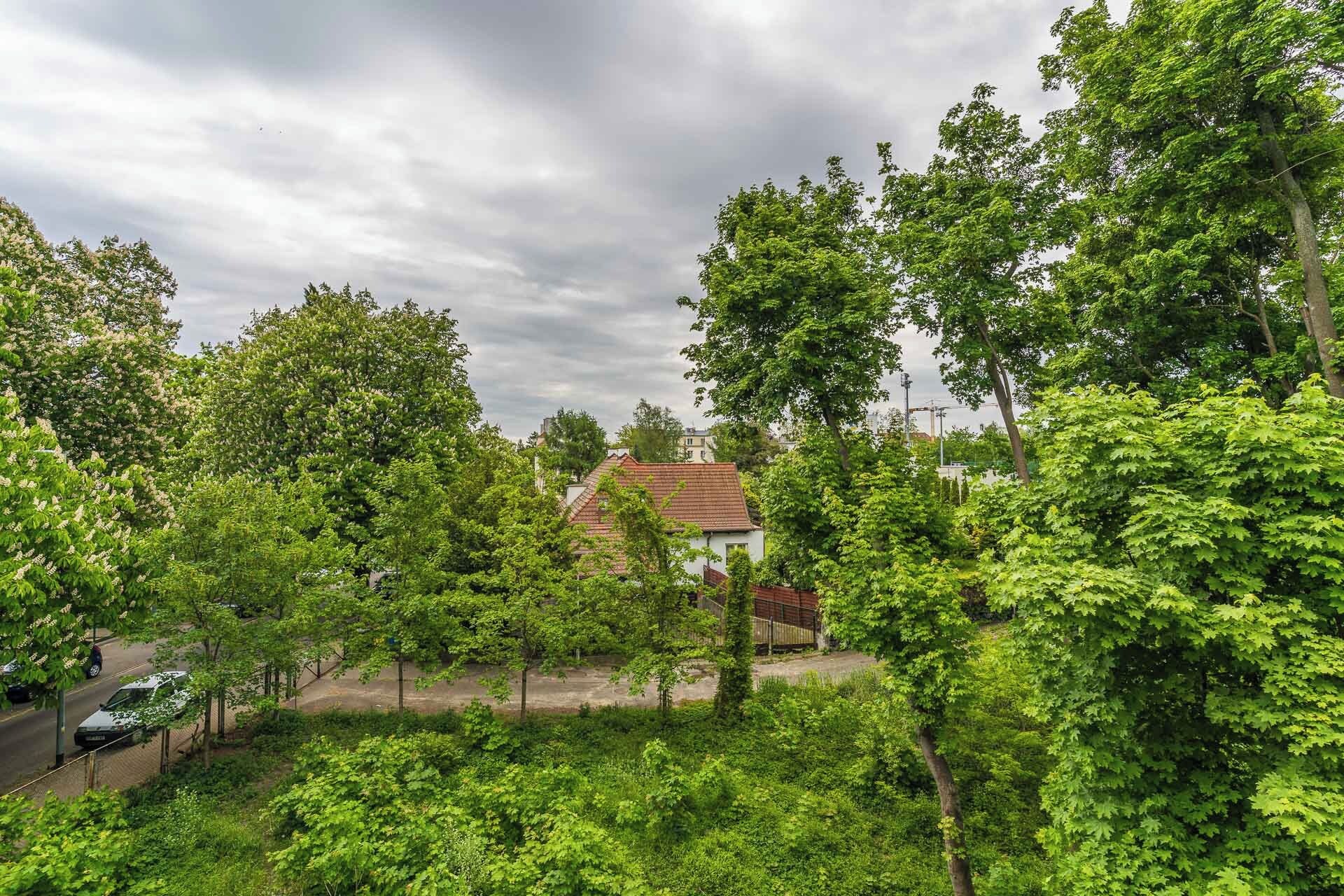 Une maison entourée d’une végétation luxuriante, sous un ciel dégagé.