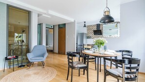 Une cuisine moderne avec un coin repas, comprenant une table ronde, des chaises et un luminaire suspendu.