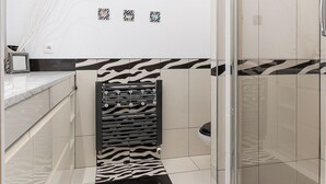 A modern bathroom with a shower, a zebra-patterned accent wall, and a minimalist design. - RentPlanet - Apartament Skoroszewska (Warsaw)