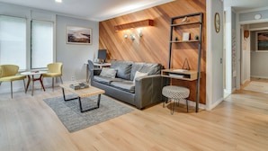 A modern living room with a sofa, a coffee table, and a bookshelf. - Relax Poolside! All-season Base in Mt Hood Village (Welches)