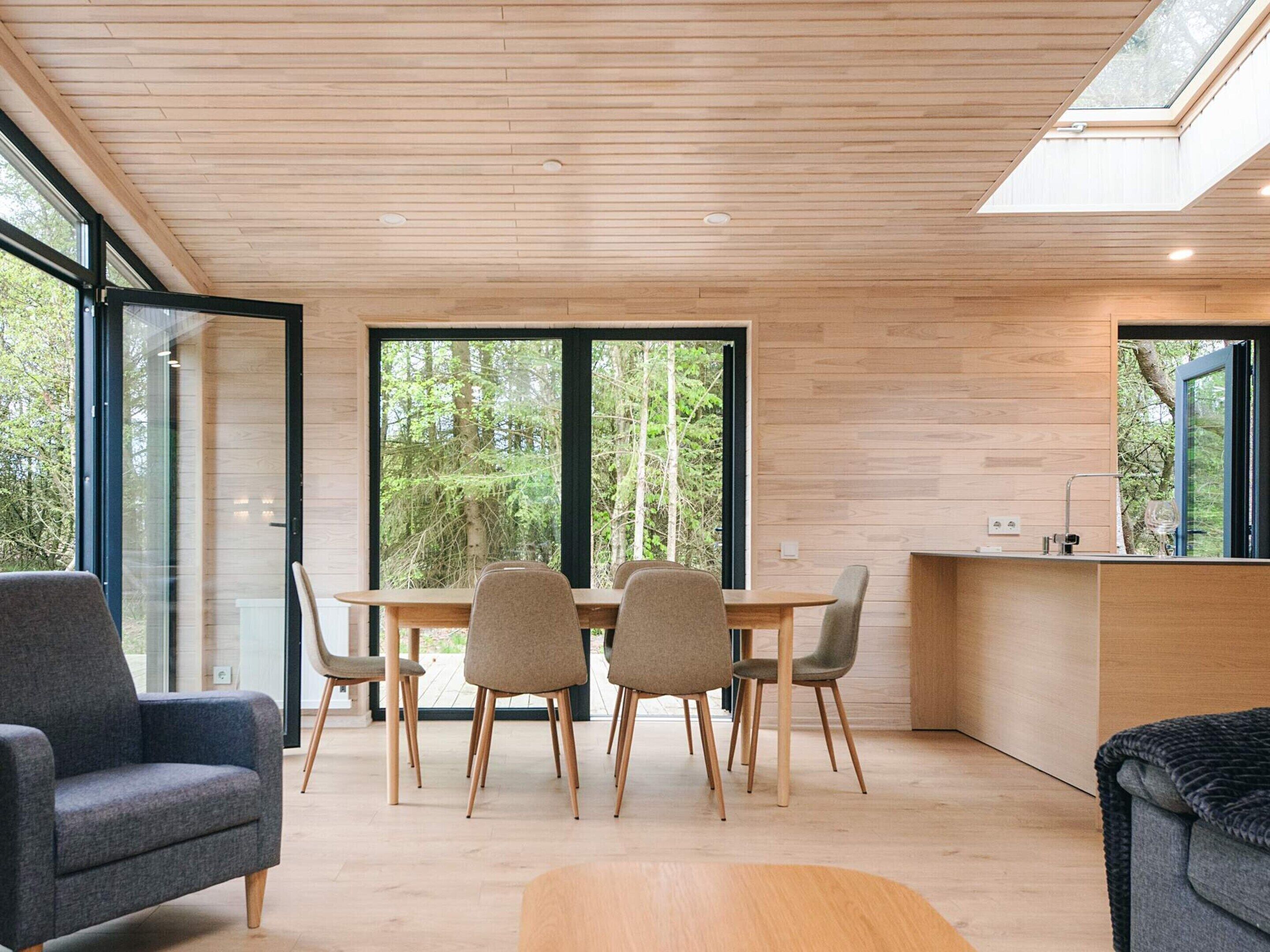 A modern interior with a dining area, kitchen, and seating space.