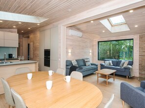 Un intérieur moderne comprenant un coin repas, des canapés et une cuisine.