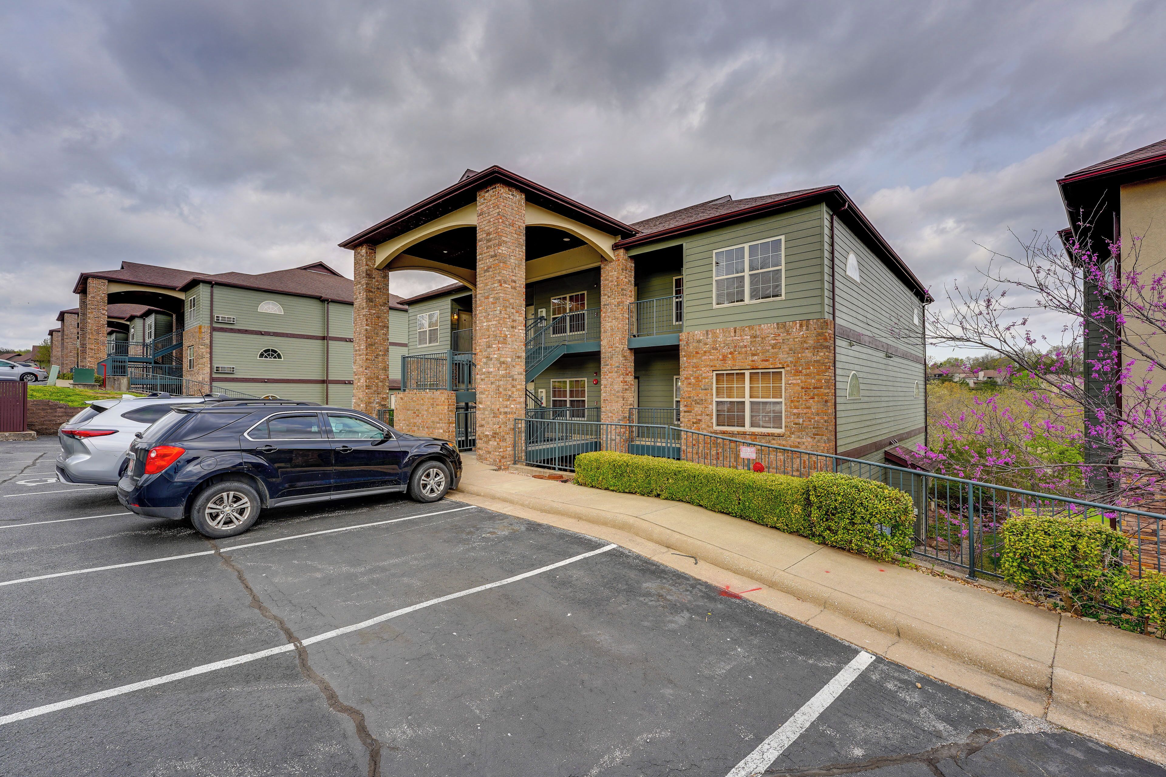 A multi-story building with a parking lot in front.