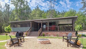 A cabin with a covered deck, outdoor seating, and a fire pit. - Couple's Retreat, Hunter's Home Base (Enigma)