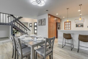 A modern kitchen with a dining area, wooden cabinets, and a staircase. - Dock! Waterfront Retreat 5 Mi to Dtwn Jacksonville (Jacksonville)