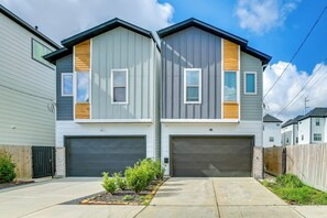 A two-story residential building with a garage, a wooden fence, and a small garden area. - < 2 Mi to Dtwn! Group Escape w/ Grill in Houston (Houston)