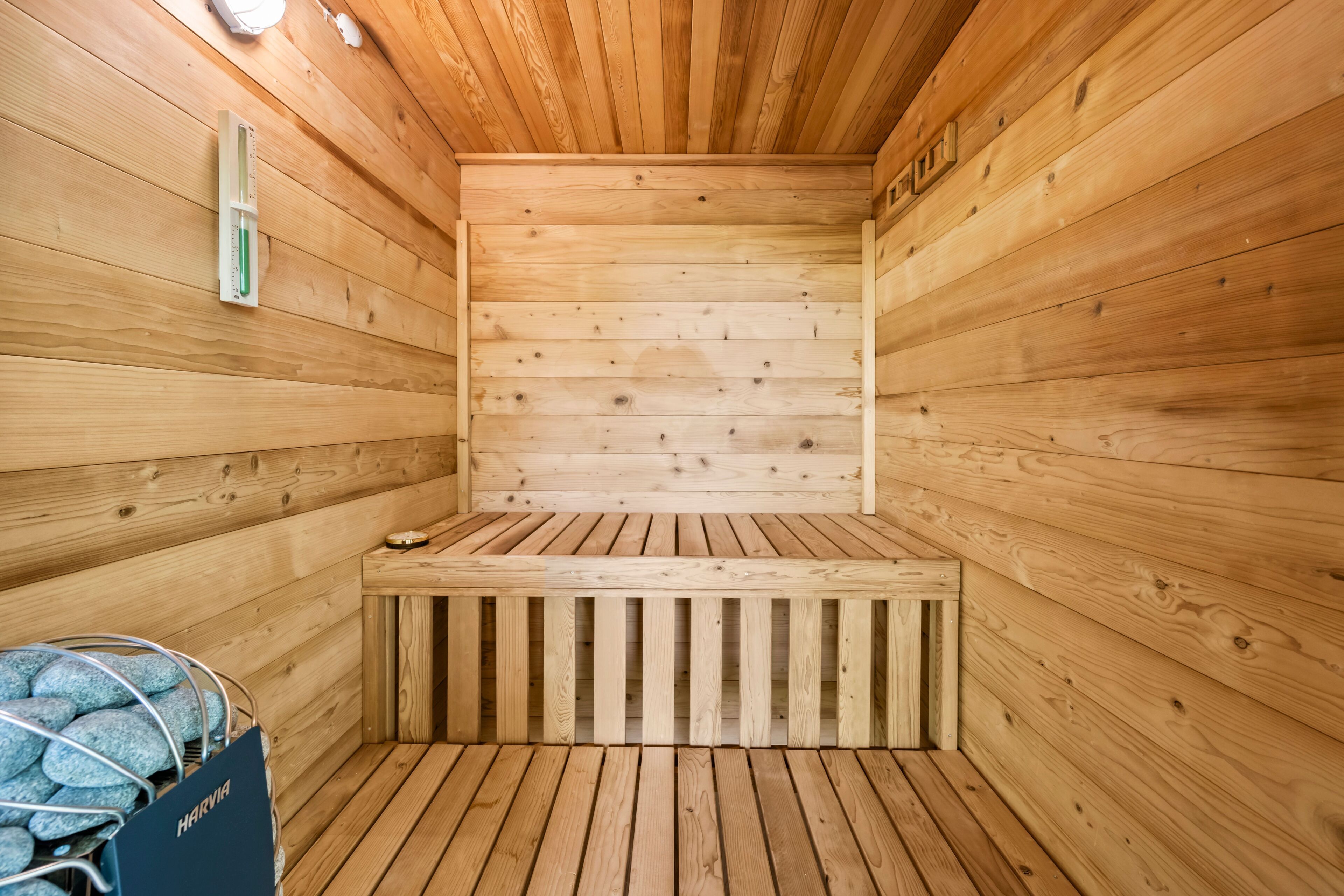 A sauna room with wooden walls and a bench.