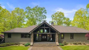 A two-story house with a stone foundation, a front porch, and a driveway. - DuPont Mountain Lodge: 28 Private Acres + Sauna (Cedar Mountain)