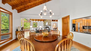 A dining area with a wooden table, chairs, and a chandelier.