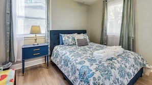 Un dormitorio con cama, mesita de noche, lámpara y ventilador de techo.