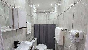 A modern bathroom with a toilet, sink, and shower curtain.