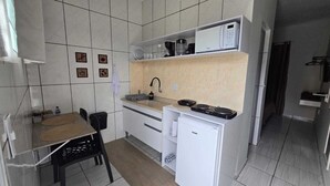 A compact kitchen with a microwave, coffee maker, and a small refrigerator.