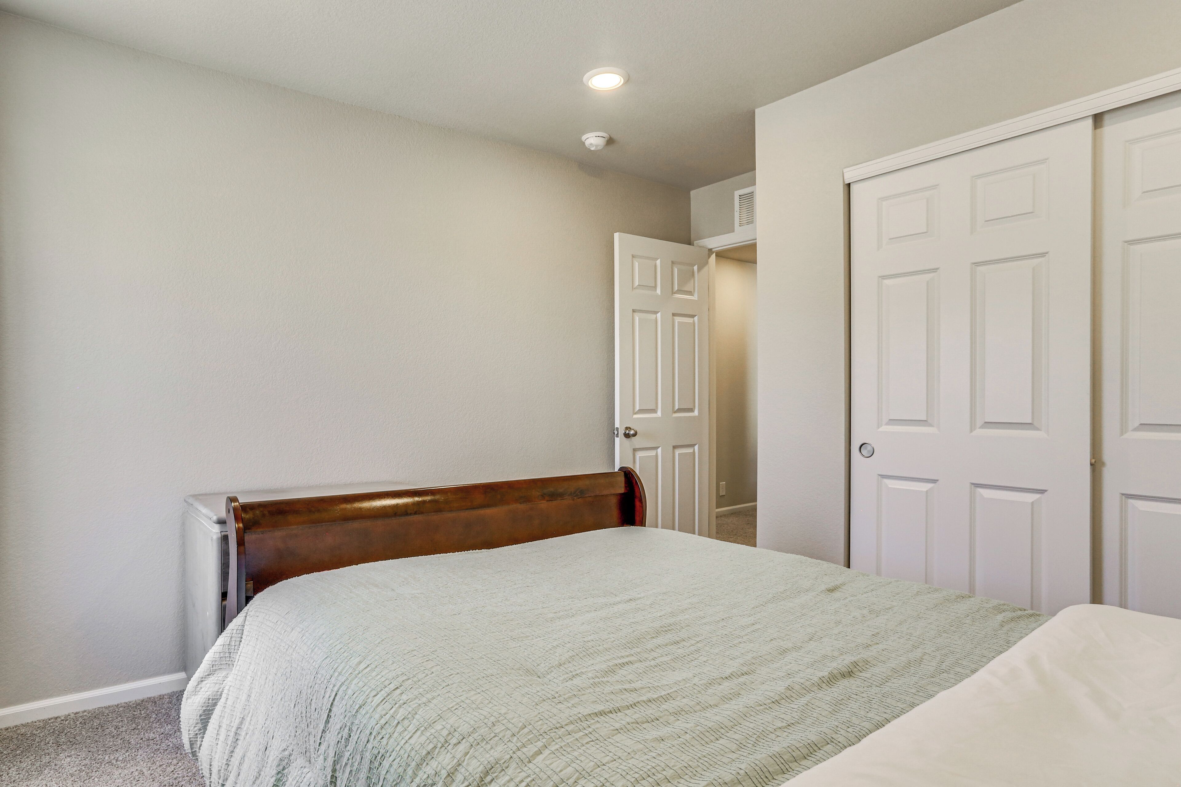 A bedroom with a bed, a radiator, and a door.