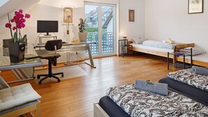 Ein modernes Apartment mit Arbeitsplatz, Bett und Balkon.