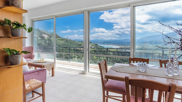 A dining area with a view of a mountainous landscape through large windows.