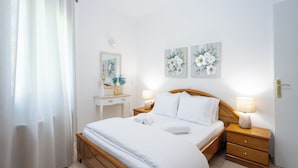 A hotel room with a bed, bedside tables, a mirror, and wall art.