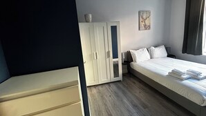 Makuuhuoneessa on sänky, vaatekaappi, yöpöytä ja seinällä taulu.