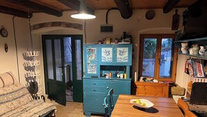 Ein gemütliches Zimmer mit einem Holztisch, einem blauen Schrank und einem Bett mit gemusterten Textilien.