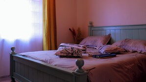 Un dormitorio con cama, cortinas y una lámpara en el techo.
