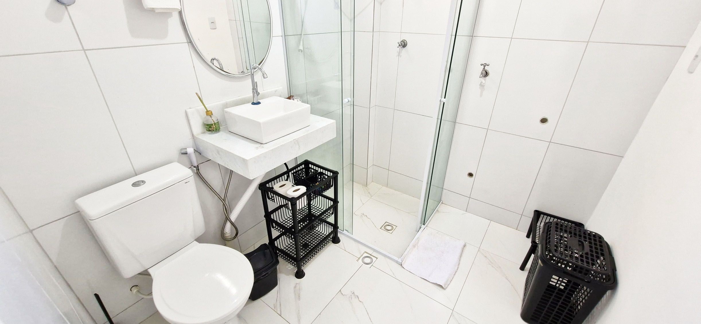 A modern bathroom with a toilet, sink, and shower area.