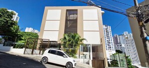 Un edificio moderno con fachada plana, ventanas amplias y una entrada protegida por un portón.