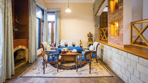 A cozy living room with a fireplace, a sofa set, and a wooden coffee table. - Alaya Stays Mehar Villa 3BHK With Garden (Kasauli)